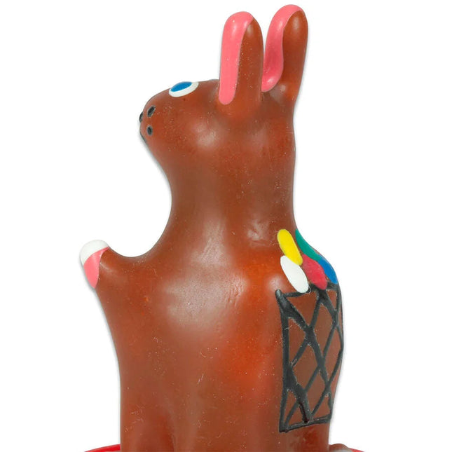 Braune keramik-osterhasenfigur mit rosa ohren und pfoten blaue augen schwarzer nase bemalter korb mit bunten pinseln