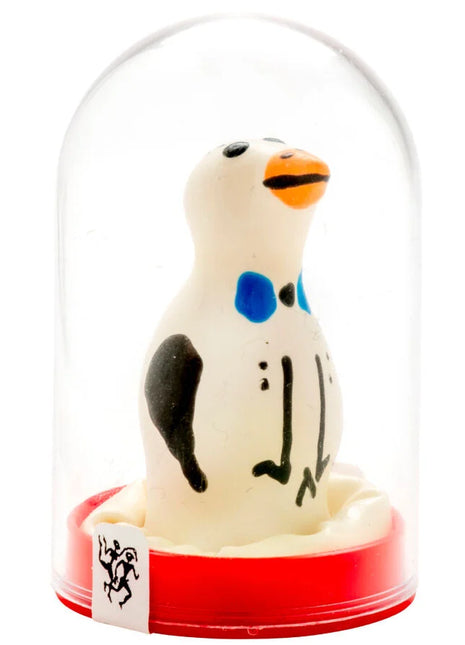 Ein charmantes weißes pinguinfigürchen mit schwarzen und blauen markierungen und oranger schnabel in einer glaskuppel auf rotem sockel aus der serie condomerie handbemalte neuheitskondome pinguin