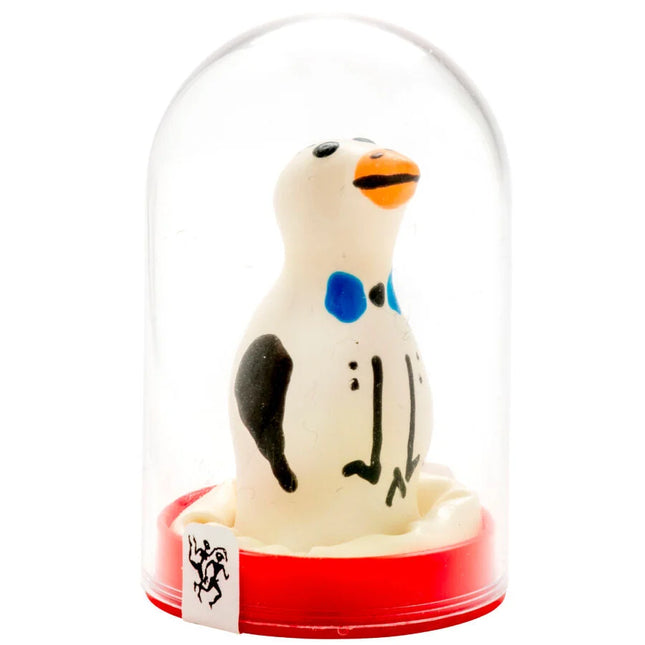 Ein charmantes weißes pinguinfigürchen mit schwarzen und blauen markierungen und oranger schnabel in einer glaskuppel auf rotem sockel aus der serie condomerie handbemalte neuheitskondome pinguin