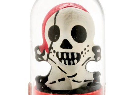 Weiße piratenschädel-figur mit schwarzen augenklappen und zähnen in rotem bandana im glaskuppelgehäuse auf rotem sockel