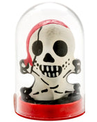 Weiße piratenschädel-figur mit schwarzen augenklappen und zähnen in rotem bandana im glaskuppelgehäuse auf rotem sockel