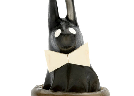 Schwarze keramik-hasenfigur mit weißen augen und cremefarbener schleife auf passendem sockel für condomerie play boy kondome