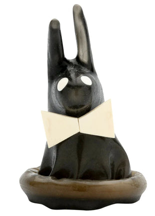 Schwarze keramik-hasenfigur mit weißen augen und cremefarbener schleife auf passendem sockel für condomerie play boy kondome