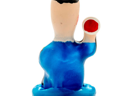 Handbemalte blaue plastikfigur eines sitzenden polizisten mit schwarzem haar und rotem rundem objekt condomerie kondom