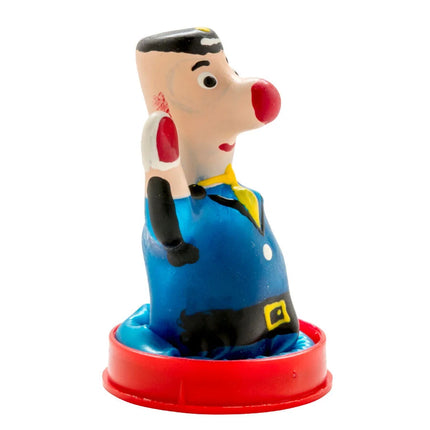 Bunte plastikfigur eines cartoon-charakters mit roter nase schwarzem haar und blauer latzhose auf rotem sockel kondome polizist