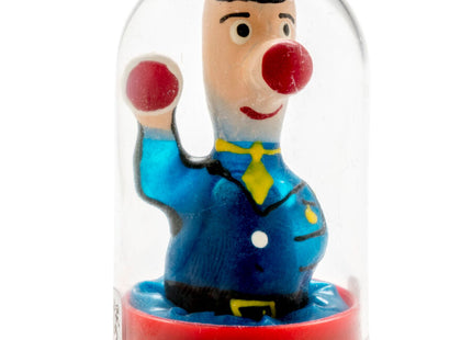 Ein fröhlicher clown in blauem anzug mit gelber krawatte und roter nase unter klarglasdom von condomerie