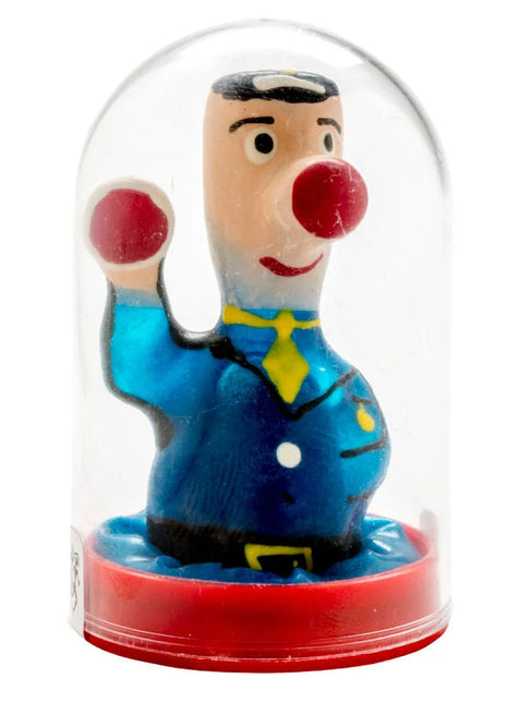 Ein fröhlicher clown in blauem anzug mit gelber krawatte und roter nase unter klarglasdom von condomerie