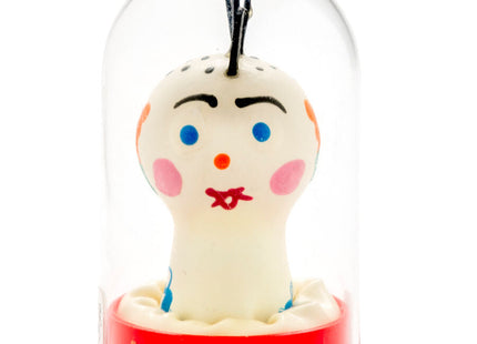 Eine handbemalte weiße keramikfigur mit blauen augen und roter schleife in glasdom auf rotem sockel von condomerie punk