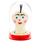 Eine handbemalte weiße keramikfigur mit blauen augen und roter schleife in glasdom auf rotem sockel von condomerie punk