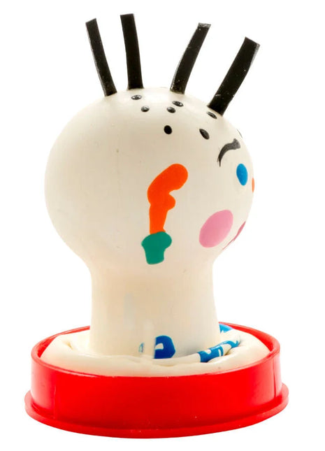 Ein weißer gummistempel mit schwarzem haar und buntem gesicht auf rotem kunststoffsockel von condomerie handbemalte neuheitskondome punk
