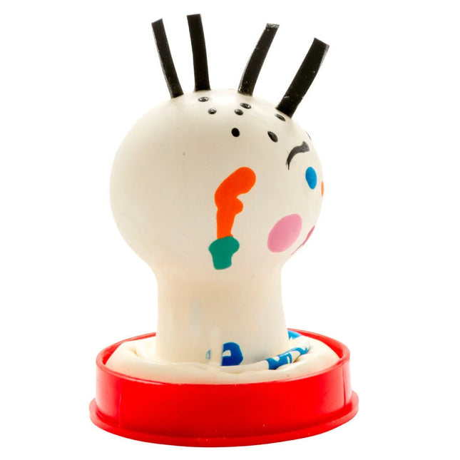 Ein weißer gummistempel mit schwarzem haar und buntem gesicht auf rotem kunststoffsockel von condomerie handbemalte neuheitskondome punk