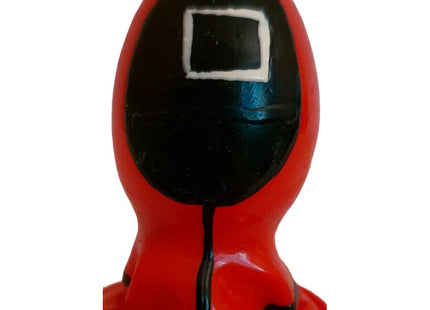 Rote plastikfigur einer figur im kapuzenanzug mit schwarzem gesicht und weißem quadrat als handbemalter condomerie kondom