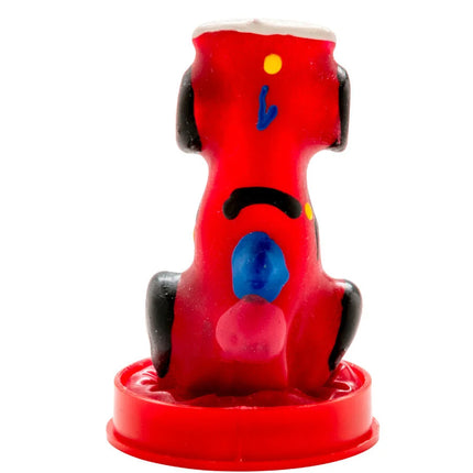 Ein lebhaft roter plastikhund mit schwarzen ohren blau gelben akzenten als handbemalte figur im condomerie rennauto set