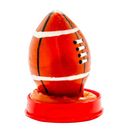 Eine glänzende orangefarbene rugbyballförmige kerze auf rotem kunststoffständer von condomerie handbemalt