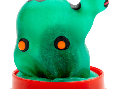 Ein grünes, glänzendes plastiktierfigürchen mit orangefarbenen augen auf rotem rundsockel von condomerie handbemalte neukondome schildkröte