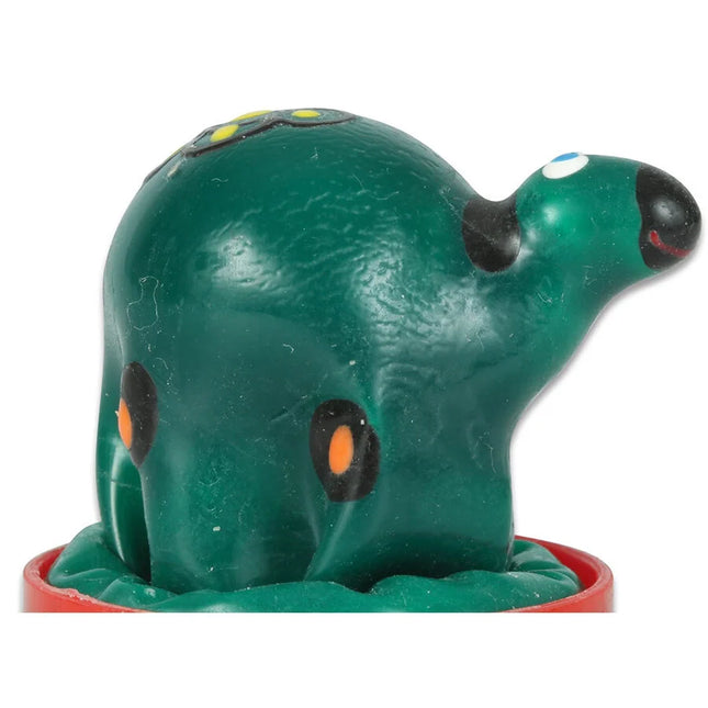 Grüner plastikspielzeug-oktopus mit schwarzen und orangen augenpunkten auf rotem rundem sockel in handbemalten neuheitskondomen schildkröte