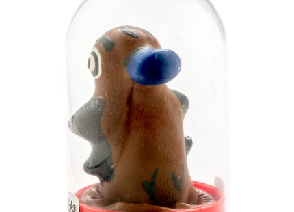 Braune tonfigur mit blauem ohr und grauen akzenten unter glaskuppel auf rotem kunststoffsockel in kondomerie kondomen