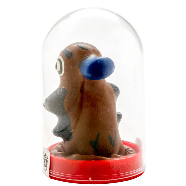 Braune tonfigur mit blauem ohr und grauen akzenten unter glaskuppel auf rotem kunststoffsockel in kondomerie kondomen