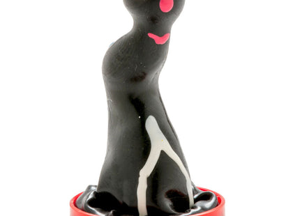 Handbemalte seelöwen kondomfigur mit schwarzem glänzendem körper, gelben und rosa augen, sitzend auf rotem kunststoffsockel