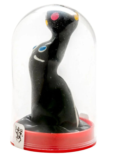 Schwarze keramikfigur mit bunten punkten und glänzender oberfläche unter glashülle aus condomerie seelöwe kollektion