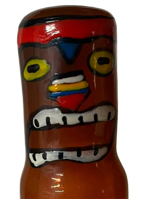 Ein glänzender brauner keramik tiki flasche mit rotem stirnband gelben augen und bunt bemalten gesichtszügen