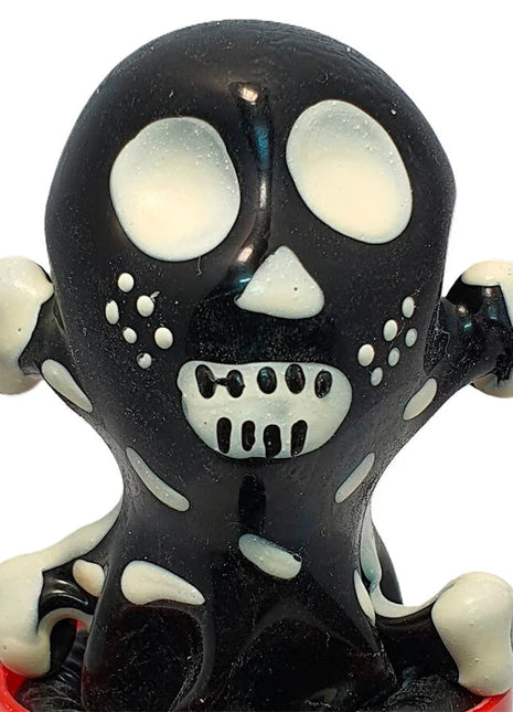Schwarz-weißes handbemaltes kondom mit glänzendem totenkopf-motiv und detaillierten augenhöhlen und grinzen