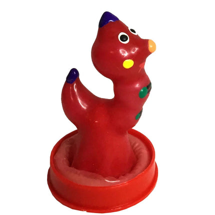 Eine rote glänzende plastikspielzeugdinosaurier mit lila spitzen, gelber nase und grünen punkten aus der condomerie handbemalte neuheitskondome wurm serie