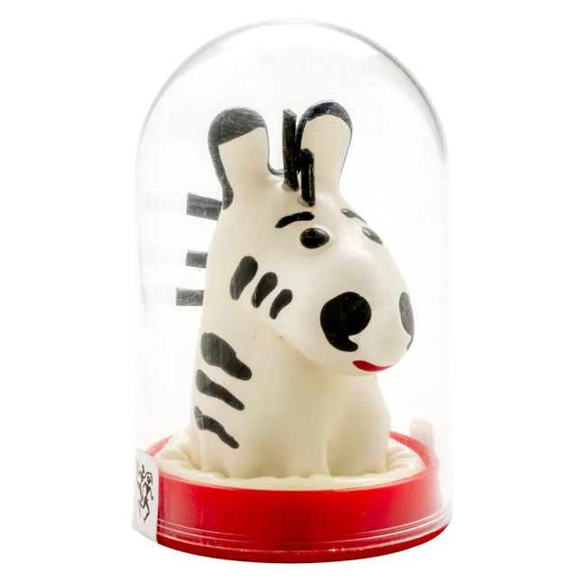 Eine charmante weiße zebrafigur mit schwarzen streifen und roten lippen unter einer glaskuppel auf rotem sockel