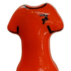 Vibrante orange keramikfigur in t-shirt-form mit schwarzen details und stilisiertem logo auf der brust