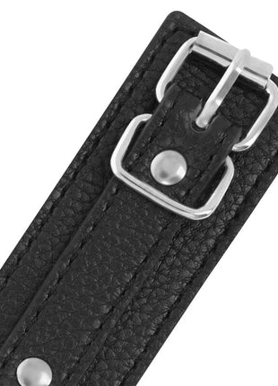 Handschellen aus schwarzem strukturiertem leder mit silbernen metallnieten und schnalle in dunkeloptik
