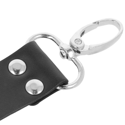 Schwarzes lederhandschellen-sets für füße und hände mit silbernen metallbeschlägen und zwei dekorativen nieten