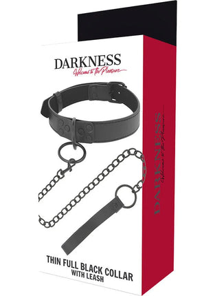 Schwarze lederhalskette mit kettenanhänger und leine verpackt in rotem und weißem darkness box