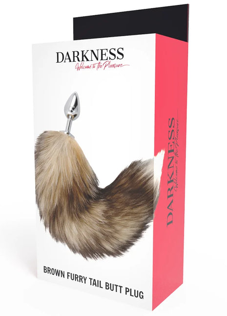 Brauner fell-schwanz butt plug mit silberner metallspitze in darkness markenverpackung sichtbar
