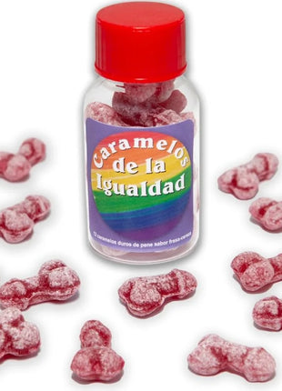 Eine klare plastikflasche mit rotem deckel und regenbogenfarbenem etikett gefüllt mit rosa, knochenförmigen erdbeer kirsch bonbons