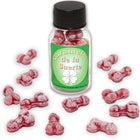 Eine klare glasflasche mit schwarzem deckel und grünem etikett gefüllt mit rosa penisförmigen glücksbonbons diablo picante erdbeere kirsche