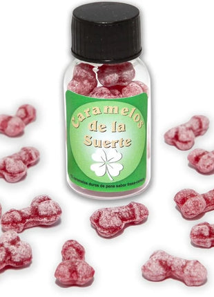 Eine klare glasflasche mit schwarzem deckel und grünem etikett gefüllt mit rosa penisförmigen glücksbonbons diablo picante erdbeere kirsche