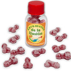 Eine klare glasflasche mit rotem verschluss und orangem etikett caramelos de la ilusión gefüllt mit rosa penisförmigen bonbons diablo picante erdbeere kirsche