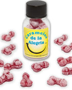 Eine klare glasflasche mit schwarzem deckel und gelbem etikett gefüllt mit rosa, penisförmigen joy-bonbons diablo picante erdbeere kirsche