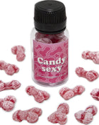 Eine klare plastflasche mit schwarzem deckel und pinkem etikett mit knochenmustern gefüllt mit roten zuckerbedeckten gummibärchen in form von penis mit erdbeer-kirsch-geschmack diablo picante candy sexy glas