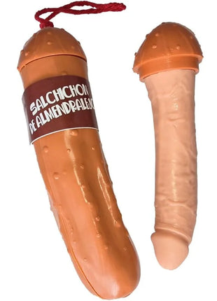 Orangenes plastikspielzeug in form einer salami mit braunem etikett salchichon de almendrales und rotem band