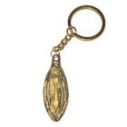 Goldfarbener metall-schlüsselanhänger diabolo picante mit detailliertem, länglichem bohnenförmigem anhänger und goldenem lippenmotiv