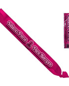 Ein lebendiger fuchsienfarbener satin-gürtel mit besticktem text und stilisiertem symbol verpackt in klarem plastik