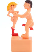 Orange Kunststofffigur eines Mannes und einer Frau in intimer Pose, Frau trägt rote Stiefel, diabolo picante scherzpuppe