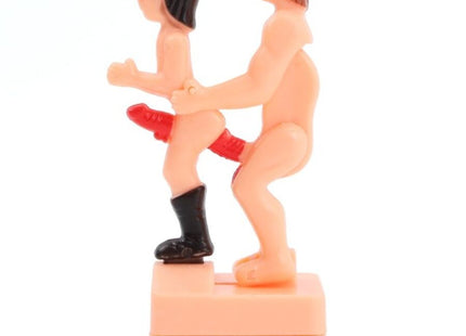 Pinkes plastikfigur diablo picante mit zwei nackten figuren eine trägt schwarze stiefel und roten string auf basis