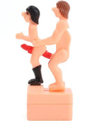 Pinkes plastikfigur diablo picante mit zwei nackten figuren eine trägt schwarze stiefel und roten string auf basis