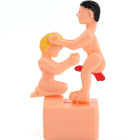 Pinkfarbene plast figurine diablo picante mit zwei spielerischen nackten figuren schwarz und blond haare