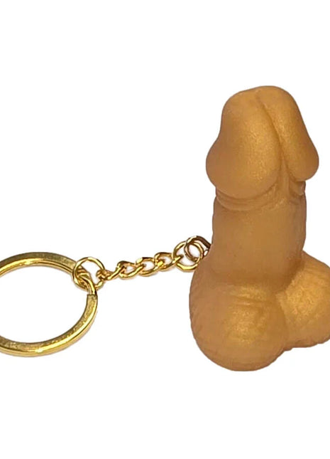 Tanfarbener silikon-schlüsselanhänger in penusform mit goldfarbenem metallring und kette diablo picante