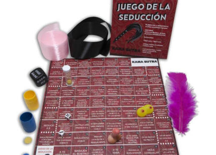Rotes kama sutra spielbrett mit spanischem text und spielfeld umgeben von würfeln, bunten bechern, feder und schwarzem gürtel