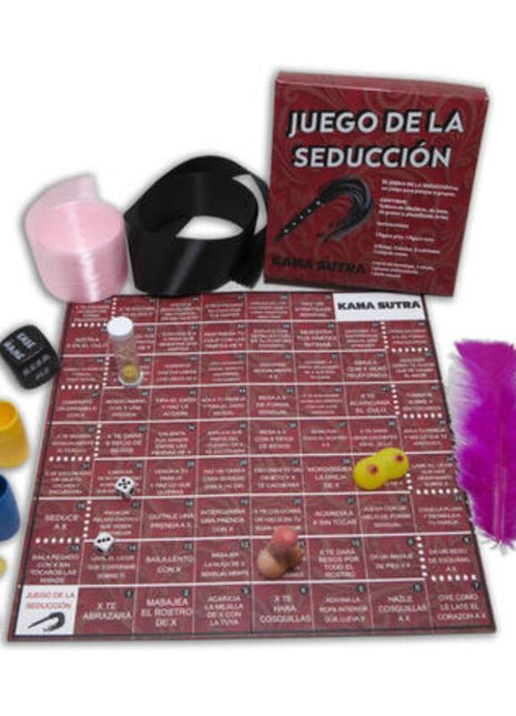 Rotes kama sutra spielbrett mit spanischem text und spielfeld umgeben von würfeln, bunten bechern, feder und schwarzem gürtel