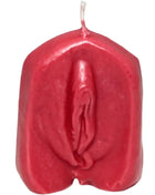 Eine vibrierend rote glänzende wachskerze mit detailliert gestalteter vulva als motiv auf der oberfläche